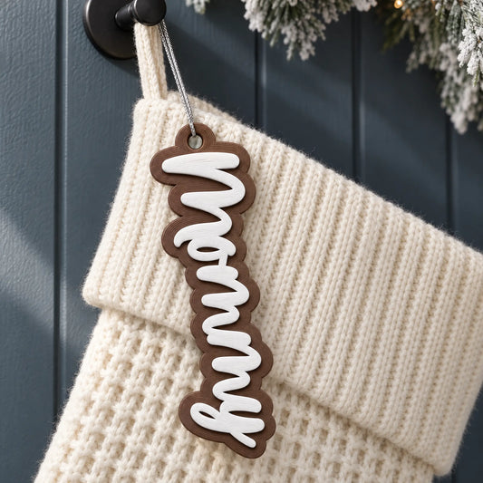 Classic Script Two-Color Stocking Name Tag: white script on a brown backing, name Nonny, on a knit Christmas stocking