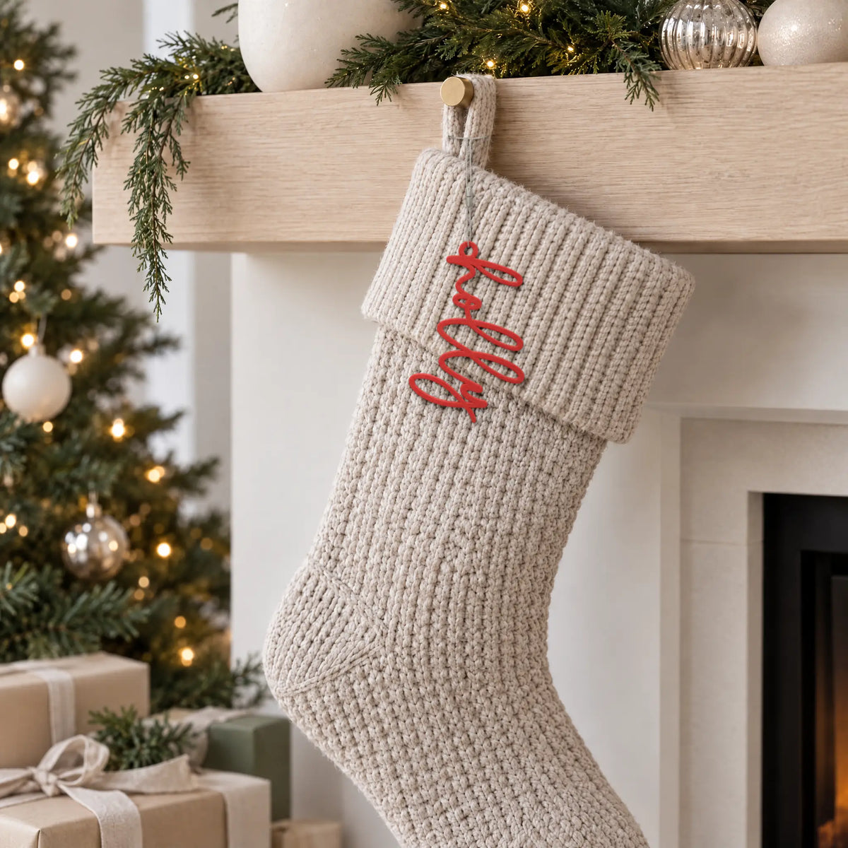 Lowercase Script stocking name tag hanging on the cuff of a knit Christmas stocking by the fireplace